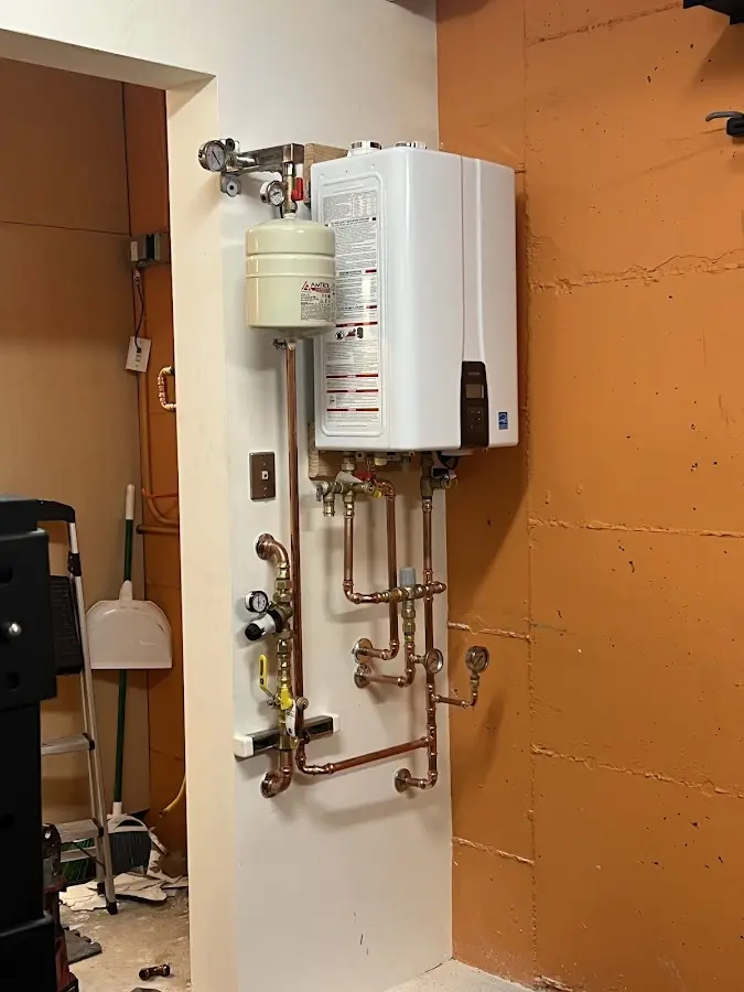 Plumbing technician inspecting water heater connections in Cedar Springs